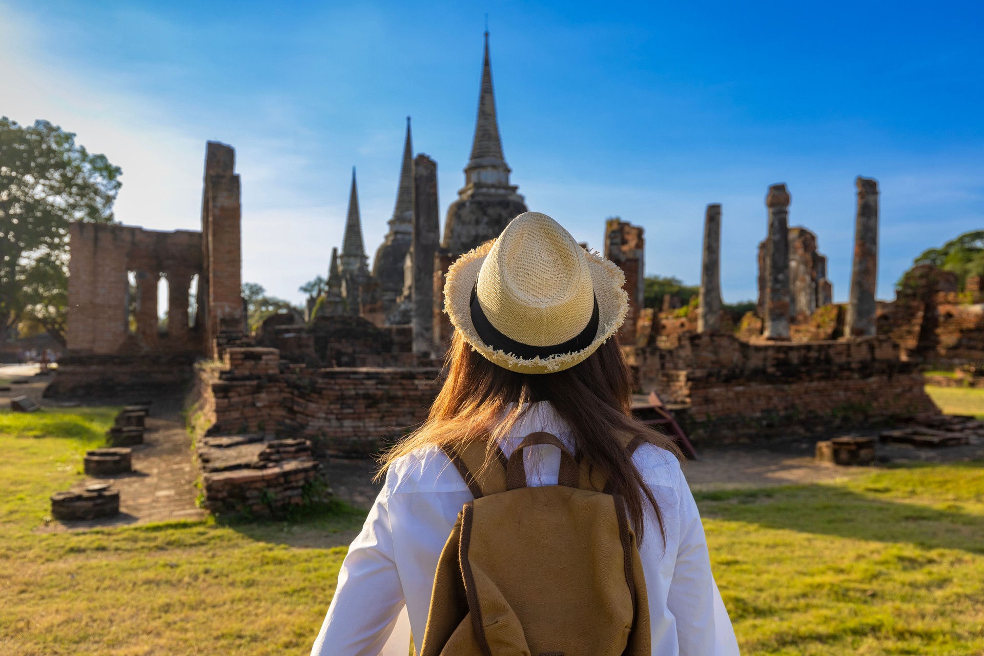 Back view of woman tourist come to visit at Wat Phra Si Sanphet temple, Ayutthaya Thailand for travel, vacation, holiday and tourism concept